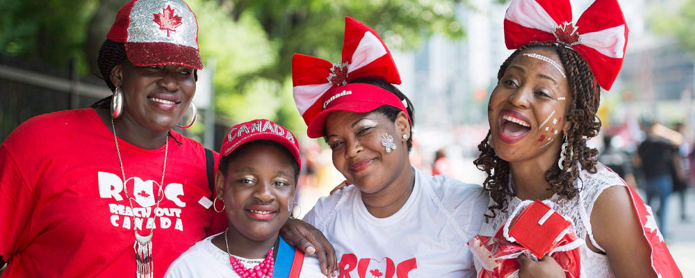 People pose for a photo prior to taking part in a Canada Day parade in Montreal, Sunday, July 1, 2018. Graham Hughes/The Canadian Press. 