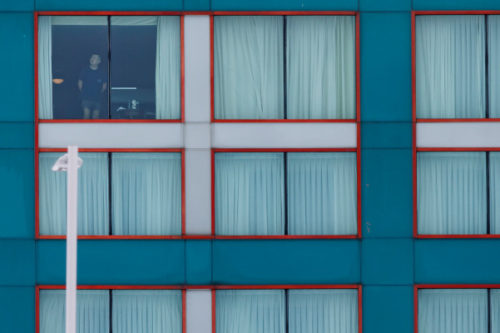 A guest looks out from a Sheraton hotel window in Mississauga, Ont. by the Pearson International Airport on Monday, Feb. 22, 2021 as new air travel rules come into effect in Canada. Cole Burston/The Canadian Press.