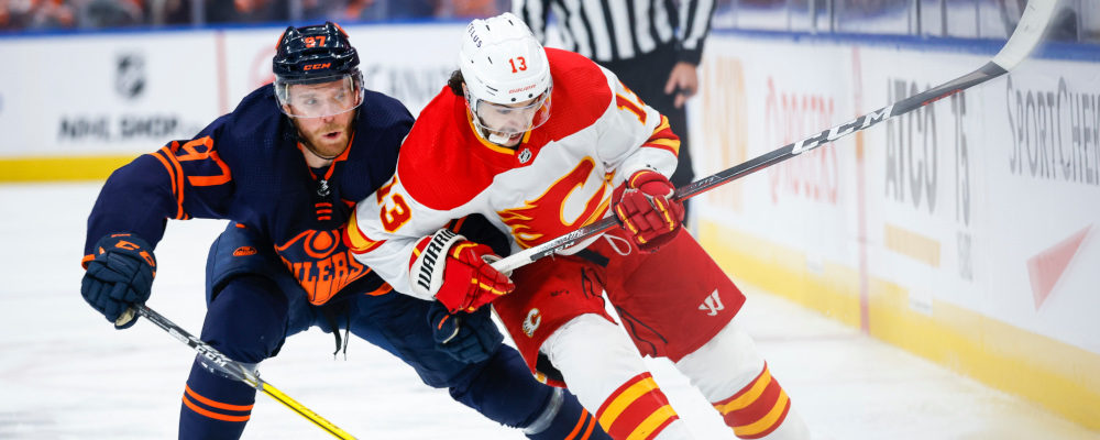 Calgary Flames forward Johnny Gaudreau, right, is checked by Edmonton Oilers centre Connor McDavid during first period NHL second-round playoff hockey action in Edmonton, Tuesday, May 24, 2022. Jeff McIntosh/The Canadian Press. 