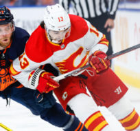 Calgary Flames forward Johnny Gaudreau, right, is checked by Edmonton Oilers centre Connor McDavid during first period NHL second-round playoff hockey action in Edmonton, Tuesday, May 24, 2022. Jeff McIntosh/The Canadian Press. 