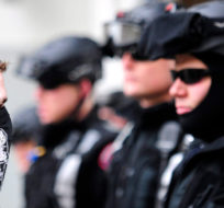 A white supremacist, left, stares down officers on a police line during a white power rally in downtown Calgary on Saturday, March 19, 2011. Police kept them apart from another group holding an anti-racist demonstration nearby. Larry MacDougal/The Canadian Press. 