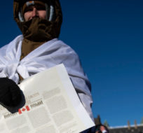 A person holds a copy of the Canadian Charter of Rights and Freedoms during a rally against COVID-19 restrictions on Parliament Hill, which began as a cross-country convoy protesting a federal vaccine mandate for truckers, in Ottawa, on Saturday, Jan. 29, 2022. Justin Tang/The Canadian Press.