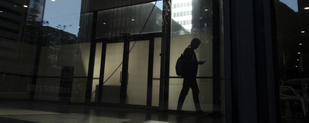 A man walks through a downtown Toronto office building with other buildings reflected in a window in this June 11, 2019 photo. Graeme Roy/The Canadian Press.