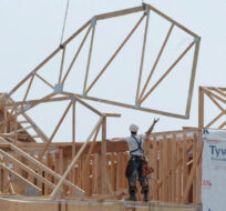 Construction workers build new homes in a development in Ottawa on Monday, July 6, 2015. Sean Kilpatrick/The Canadian Press.