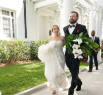 Arielle Agnelli and Bryan Arvesu head to a photo shoot after being married during a Valentine's Day group wedding ceremony, Monday, Feb. 14, 2022, outside the Flagler Museum in Palm Beach, Fla. Wilfredo Lee/AP Photo.