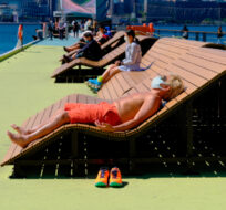 A man wearing a face mask enjoys sun bathing at a waterfront park in Hong Kong, Tuesday, March 8, 2022. Vincent Yu/AP Photo.
