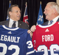 Quebec Premier Francois Legault, left, exchanges hockey jerseys with Ontario Premier Doug Ford on November 19, 2018. Chris Young/The Canadian Press.