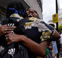 Revellers hug during the annual Notting Hill Carnival in west London, Monday, Aug. 29, 2022. The carnival which returned to the streets for the first time in two years, after it was thwarted by the pandemic, is one of the largest festival celebrations of its kind in Europe. Alberto Pezzali/AP Photo.