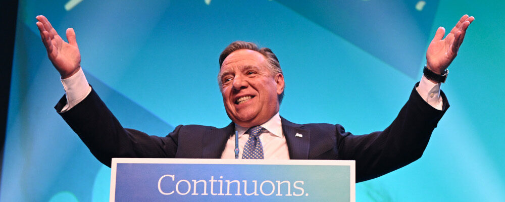 Coalition Avenir Quebec Leader Francois Legault raises his arms as he walks on stage for his victory speech on Monday, October 3, 2022 in Quebec City. Jacques Boissinot/The Canadian Press. 