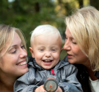In this photo taken Tuesday, Sept. 20, 2016, Albin's mother Emelie Eriksson, left, smiles as she poses for a photo with her son and her mother Marie, right, outside her home in Bergshamra, Sweden. Eriksson was the first woman to have a baby after receiving a womb transplant from her mother, a revolutionary operation that links three generations of their family.  Niklas Larsson/AP Photo.