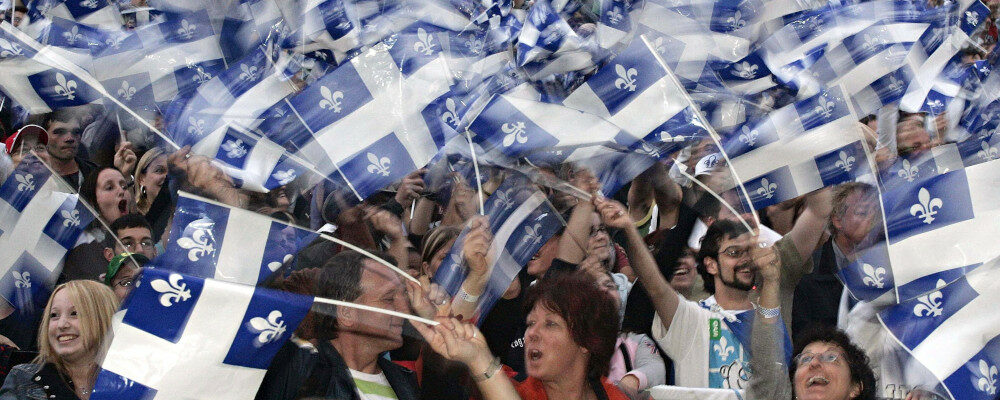 Quebecers wave their flags during celebrations of the Fete Nationale on the Plaines of Abraham Thursday June 23, 2005 in Quebec City. Jacques Boissinot/CP Photo.