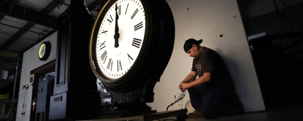 Electric Time technician Dan LaMoore lights up a two-dial Howard Post Clock on March 9, 2021, in Medfield, Mass. Elise Amendola/AP Photo.