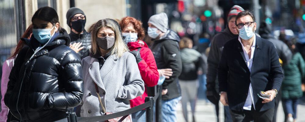 People wear face masks as they wait to enter a store in Montreal, Friday, April 2, 2021. Graham Hughes/The Canadian Press.