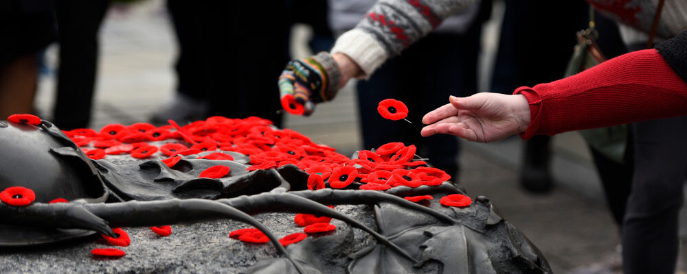 People place poppies on the Tomb of the Unknown Soldier at the National War Memorial following the National Remembrance Day Ceremony in Ottawa, on Thursday, Nov. 11, 2021. Justin Tang/The Canadian Press.