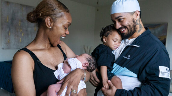 Aaliyah Wright, 25, of Washington, reacts on seeing a smile from her newborn daughter Kali, as her husband Kainan Wright, 24, of Washington, holds their son Khaza, 1, during a visit to the children's grandmother in Accokeek, Md., Tuesday, Aug. 9, 2022. Jacquelyn Martin/AP Photo.