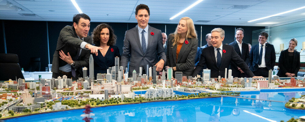 Martin Imbleau, president of the Port of Montreal, points out various sites on a scale model of the City of Montreal to Veronique Proulx, Prime Minister Justin Trudeau, Sports Minister pascale St-Onge and Francois-Philippe Champagne, Minister of Innovation, Science and Industry, in Montreal, on Monday, November 7, 2022. Paul Chiasson/The Canadian Press.