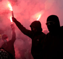 Protesters hold flares during a demonstration, in Nantes, western France, Tuesday, Oct. 18, 2022. Jeremias Gonzalez/AP Photo.