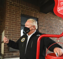 Ontario Premier Doug Ford makes a cash donation after delivering food at the Salvation Army food bank on Oct. 9, 2020. Nathan Denette/The Canadian Press.