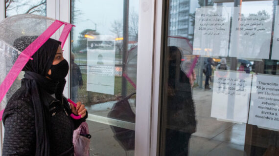 A parent reads closure notices on the front door of Thorncliffe Park Public School in Toronto on Friday December 4, 2020. Frank Gunn/The Canadian Press.