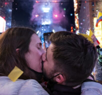 Irene Mayoral, left and Gerald Nuell, of Spain, kiss as they celebrate in Times Square in New York shortly after midnight Saturday, Jan. 1, 2022. Craig Ruttle/AP Photo.