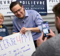 Four year old Graeme Ballingall has a photo taken with federal Conservative leadership candidate Pierre Poilievre after a campaign rally in Toronto, Saturday, April 30, 2022. Chris Young/The Canadian Press.