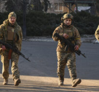 Ukrainian soldiers walk along a street in the area of the heaviest battles with the Russian invaders in Bakhmut, Ukraine on Dec. 20, 2022. Andriy Andriyenko/AP Photo.