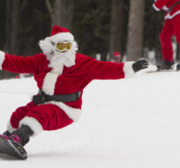 This snowboarding Santa Claus has obviously read the research showing that "experiential" gifts give us more enduring happiness than material ones.  Jonathan Hayward/The Canadian Press.