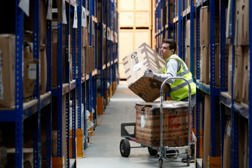 Lovespace warehouse worker Pawel Mazur unloads boxes from a trolley to place them into their allocated zones at the warehouse in Dunstable, England Monday, Jan. 14, 2019. Alastair Grant/AP Photo.