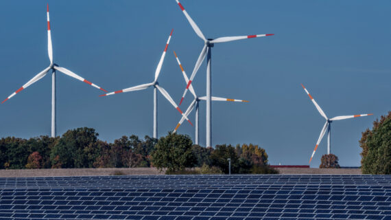 Wind turbines turn behind a solar farm in Rapshagen, Germany, Thursday, Oct. 28, 2021. Michael Sohn/AP Photo.