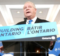 Healthcare workers stand behind Premier of Ontario Doug Ford as he makes an announcement at the Ottawa Hospital Civic Campus in Ottawa, Friday, March 25, 2022. Justin Tang/The Canadian Press.