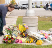 A women places flowers outside the Innisfil Police Station in Innisfil, Ontario, on Wednesday, Oct 12, 2022. Arlyn McAdorey/The Canadian Press.