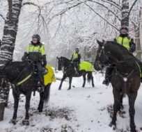 Montreal mounted police officers stay out of the snow in front of the COP15 conference as the city deals with the first major snowstorm of the season, Friday, December 16, 2022  in Montreal. Ryan Remiorz/The Canadian Press. 