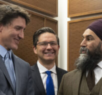 Prime Minister Justin Trudeau shakes hands with New Democratic Party leader Jagmeet Singh as Conservative leader Pierre Poilievre looks on at a Tamil heritage month reception, Monday, January 30, 2023 in Ottawa. Adrian Wyld/The Canadian Press. 