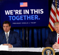 Florida Gov. Ron DeSantis, left, listens as President Donald Trump speaks during a roundtable discussion on the coronavirus outbreak and storm preparedness at Pelican Golf Club in Belleair, Fla., Friday, July 31, 2020. Patrick Semansky/AP Photo.