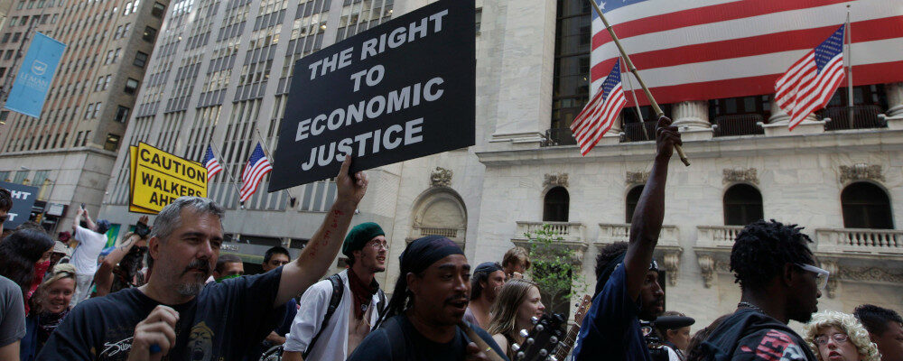 In this July 11, 2012 file photo, Occupy Wall Street protestors walk past the New York Stock Exchange in New York. Frank Franklin II/AP Photo.