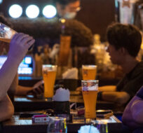 Residents drink beer at a bar after work hours in Hong Kong, Wednesday, Oct. 19, 2022. Vernon Yuen/AP Photo.