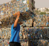 A "Verynile" initiative worker carries compressed plastic bottles in Cairo, Egypt on Sept. 15, 2022.  Reducing waste while boosting recycling and reuse, known as the "circular economy," will be vital for halting the loss of nature, organizers of the World Circular Economy Forum said Wednesday, Dec. 7. Amr Nabil/AP Photo.