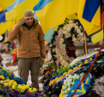 A Ukrainian serviceman salutes standing between the graves of soldiers during the funeral of Hennadii Kovshyk, who was killed on the frontline in eastern Ukraine, in Kharkiv, Ukraine, Thursday, Feb. 16, 2023. Vadim Ghirda/AP Photo.