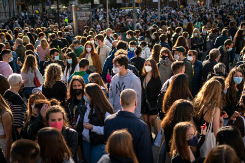 People wearing face masks crowd along a street of Barcelona on Friday, April 23, 2021. Emilio Morenatti/AP Photo.