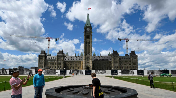 Visitors to Parliament Hill take in the Centennial Flame in front of Centre Block’s Peace Tower, in Ottawa, on Friday, June 17, 2022. Justin Tang/The Canadian Press. 