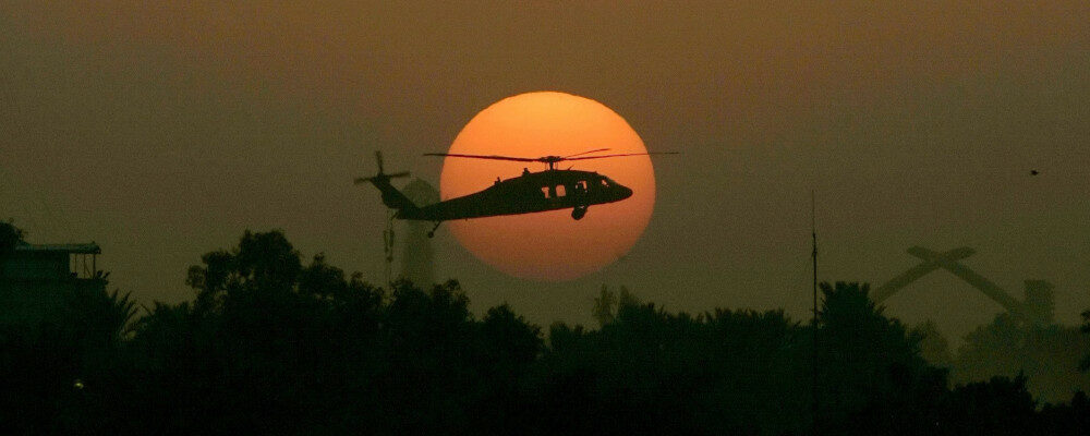 In this Tuesday, Oct 30, 2007 file photo, a U.S. army Black Hawk helicopter flies as the sun sets over Baghdad. Marko Drobnjakovic/AP Photo.