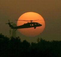 In this Tuesday, Oct 30, 2007 file photo, a U.S. army Black Hawk helicopter flies as the sun sets over Baghdad. Marko Drobnjakovic/AP Photo.