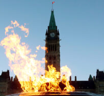 The Centre Block of the Parliament Buildings is shown through the Centennial Flame on Parliament Hill in Ottawa. Fred Chartrand/The Canadian Press.