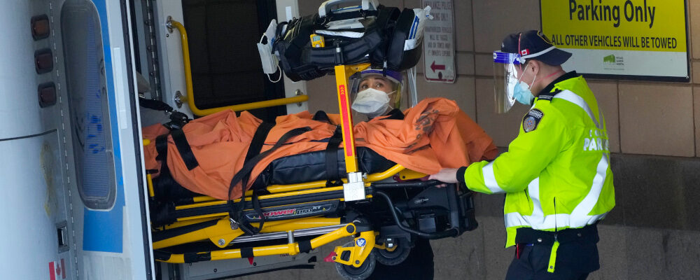 Paramedics transfer a patient out of their ambulance to the emergency department at Michael Garron Hospital in Toronto on Monday, January 10, 2022. Nathan Denette/The Canadian Press. 