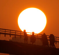 People watch the first sunrise and take pictures on New Year's Day from a pedestrian bridge in Seoul, South Korea, Sunday, Jan. 1, 2023. Lee Jin-man/AP Photo.