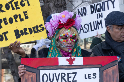 Refugees and their supporters call for open borders as they take part in a protest in front of Prime Minister Justin Trudeau's riding office, in Montreal, Tuesday, April 4, 2023. Ryan Remiorz/The Canadian Press. 