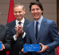 CEO of Volkswagen Group Oliver Blume (second from left) and board member Thomas Schmall applaud as Prime Minister Justin Trudeau and German President Frank-Walter Steinmeier hold up EV battery cells they signed during an event on Parliament Hill, Monday, April 24, 2023 in Ottawa. Adrian Wyld/The Canadian Press.