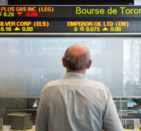 A man watches the financial numbers at the TMX Group in Toronto's financial district on May 9, 2014. Darren Calabrese/The Canadian Press. 