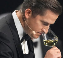 Raimonds Tomsons of Latvia, smells at a glass of white wine during the Best Sommelier of the World in Paris, Sunday, Feb. 12, 2023. Michel Euler/AP Photo.