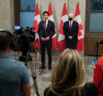 Journalists listen as Prime Minister Justin Trudeau stands with Minister of Foreign Affairs Marc Garneau make an announcement on Parliament Hill in Ottawa, on Friday, Sept. 24, 2021. Justin Tang/The Canadian Press. 
